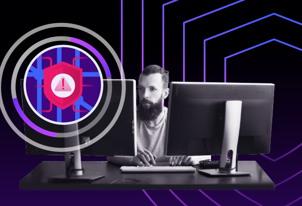 Illustration of a person working at dual monitors as a cyber threat alert icon overlays the screen, representing a web-based security attack.