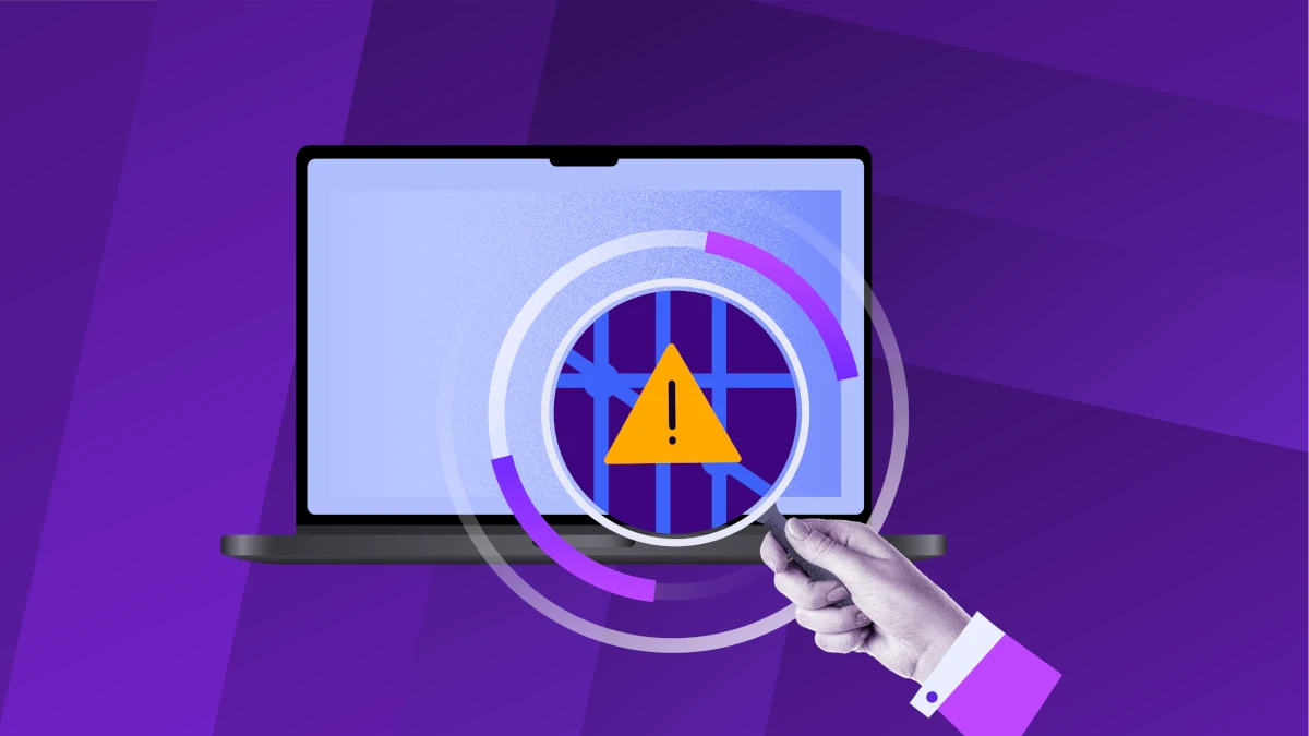 Magnifying glass highlighting a warning icon on a laptop screen, representing detection of ransomware or suspicious activity.